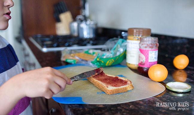 boy making peanut butter jelly sandwich