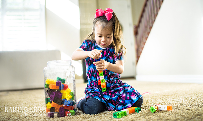 toddler playing with math counting cubes