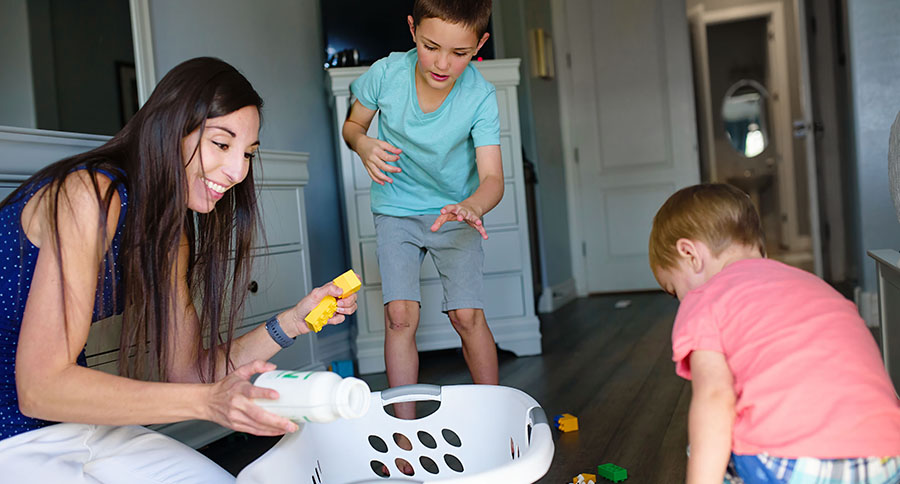 mom and sons cleaning up toys