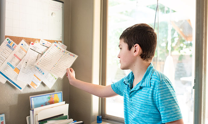 boy reacing for a laminated sheet of exercises