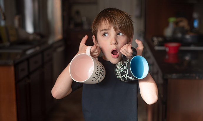 boy holding coffee mugs