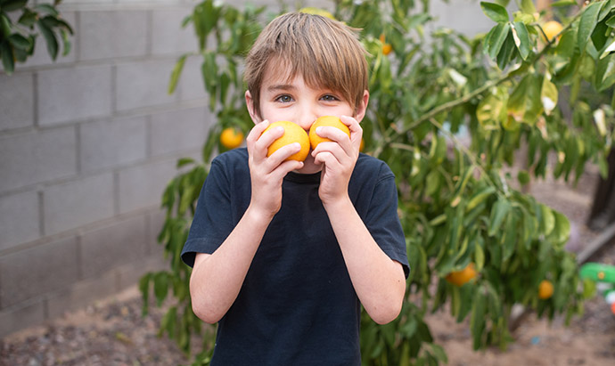 boy sniffing oranges