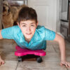 boy riding on a scooter board in kitchen