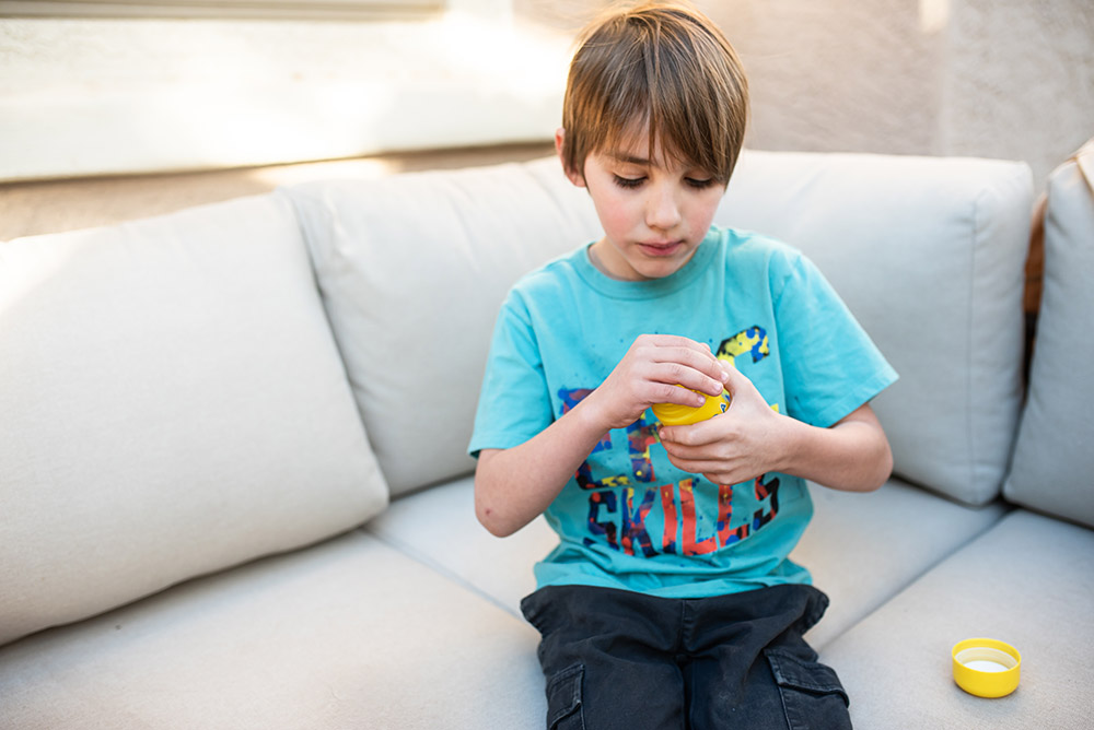 boy dumping out Hiya vitamins