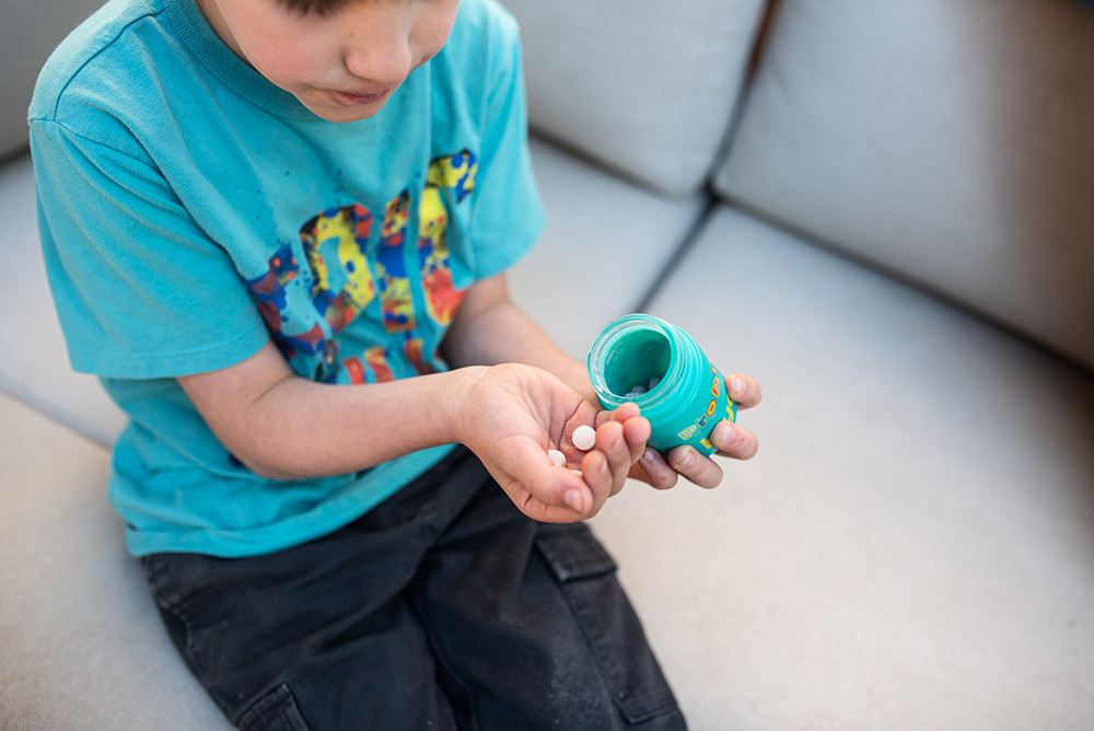 boy pouring out Hiya vitamins into his hand