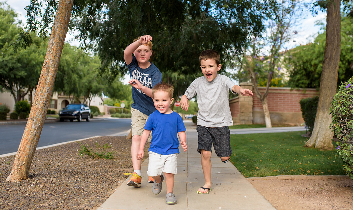 boys running down sidewalk