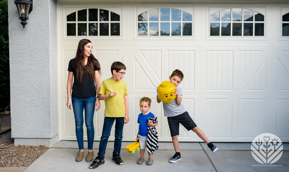 mom and sons with lego head in front of garage