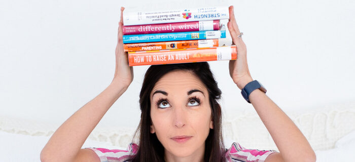 parent coach holding parenting books on head