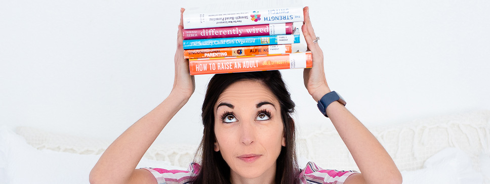 parent coach holding parenting books on head