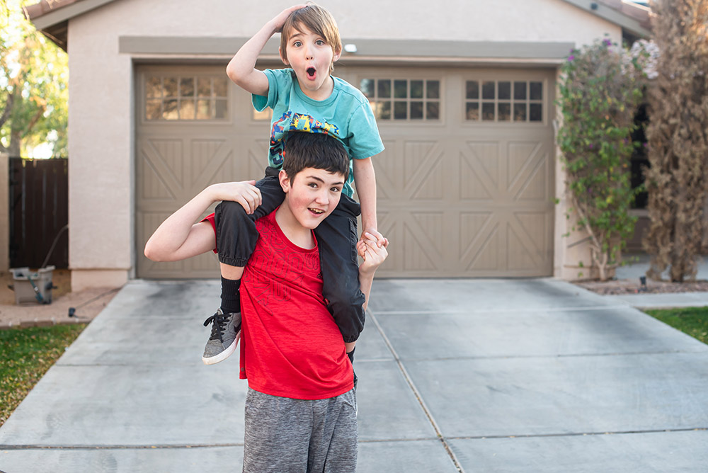 big brother carrying little brother on his shoulders