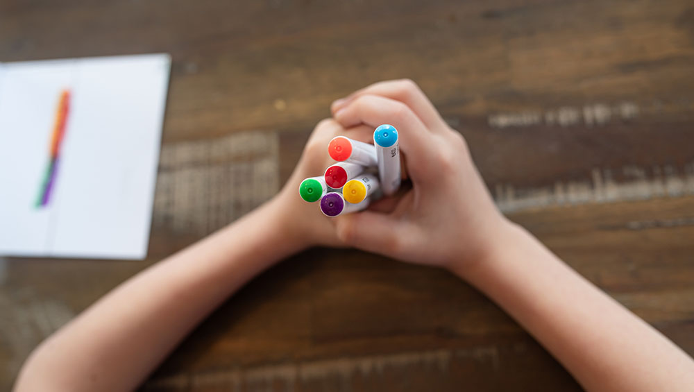 8 year old holding watercolor markers