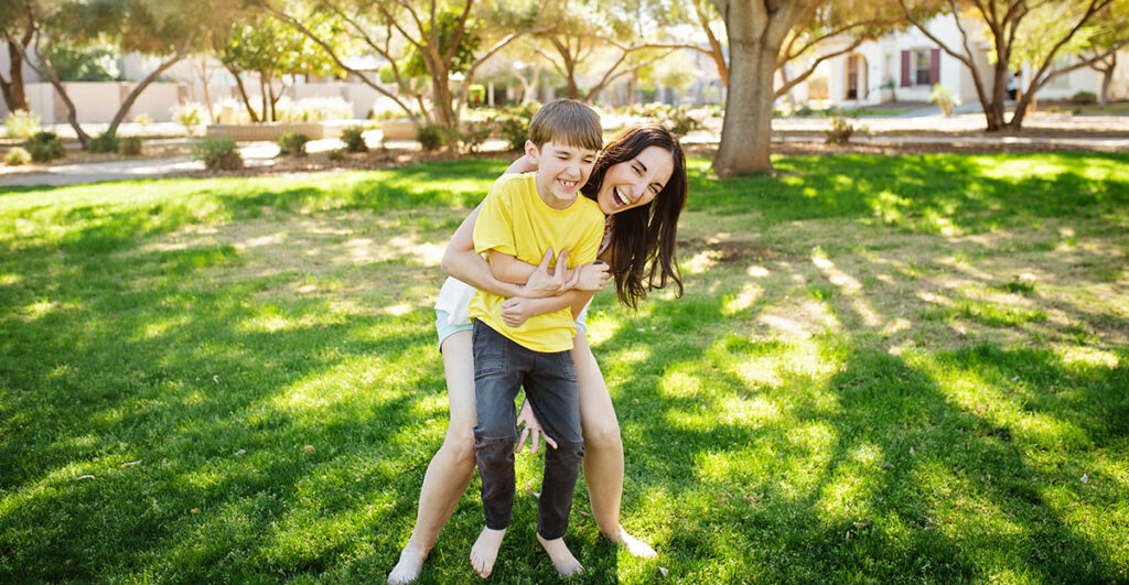 mom and son hugging in park in AZ