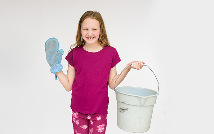 girl holding bucket and cleaning glove