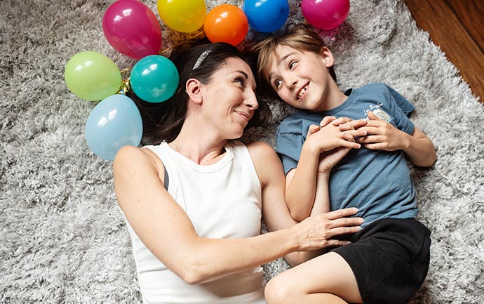 daily momens of connection - mom and son lying on floor together with balloons