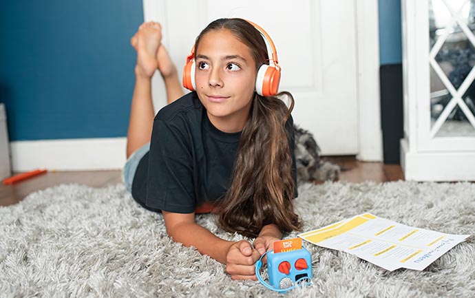 little girl listening to her portable Yoto Player