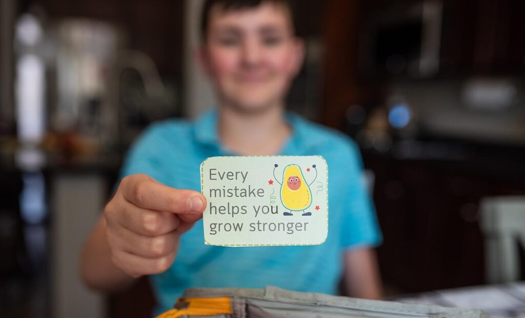 boy holding an affirmation he found in his lunchbox
