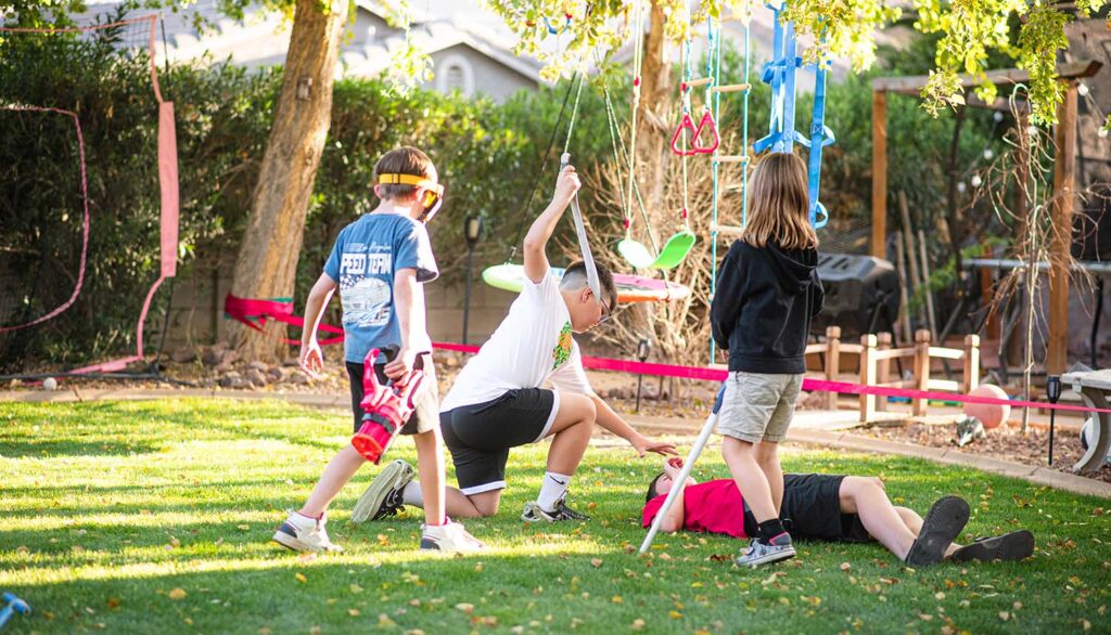 boys playing with swords in backyard