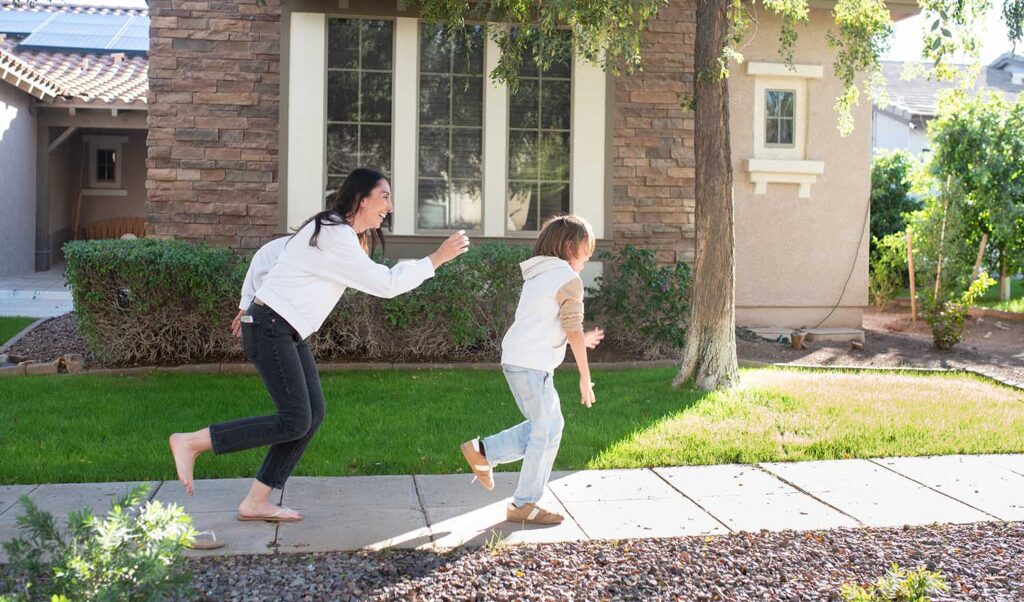 mom pretending to chase son down side walk